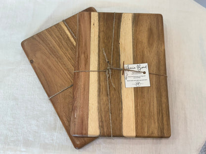 Two wooden cutting boards with a visible brand label on a white surface