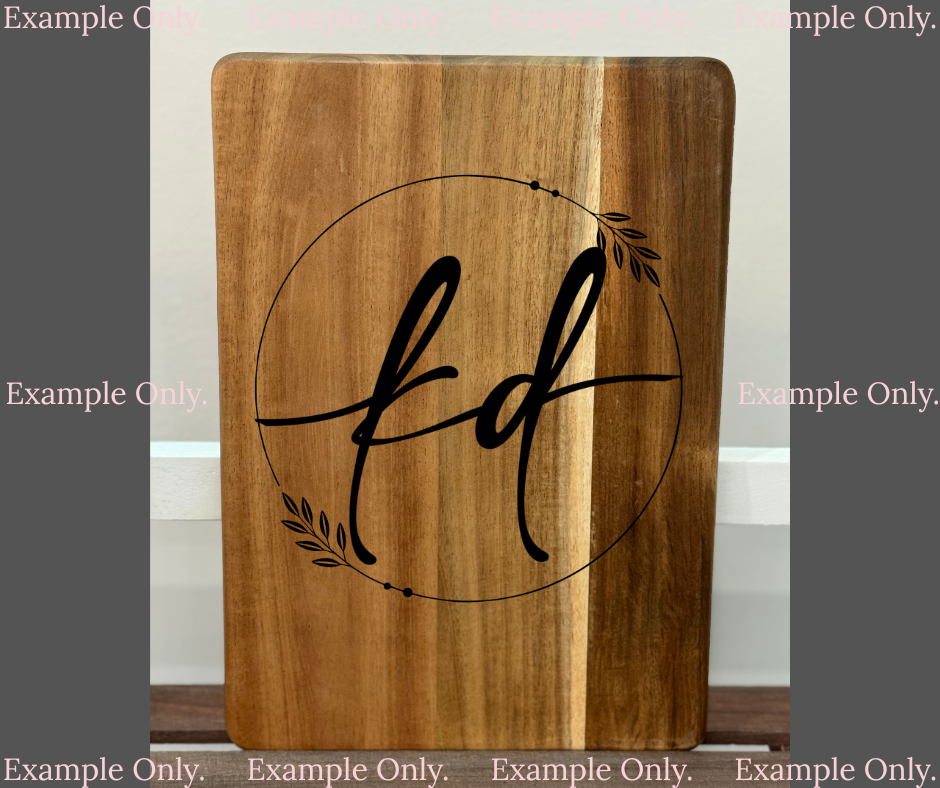 Wooden cutting board with 'kd' initials in a circular design on a plain background