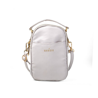 Light gray crossbody bag with gold accents on a white background