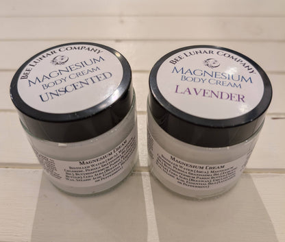 Two jars of magnesium body cream from the Bee Luhar Company on a tiled floor.